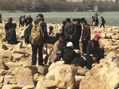 市民在河边捡石头