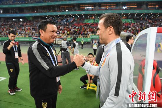 资料图：2019中国杯揭幕战开赛前，泰国队主帅西里萨克-约戴雅德泰与卡纳瓦罗握手。 俞靖 摄