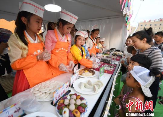 中国朝鲜族小学生带来自制美食进行义卖，帮助学校里的贫困同学。　张瑶 摄