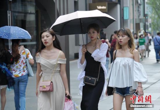 资料图：街头来来往往的时尚人士。 中新社记者 刘忠俊 摄