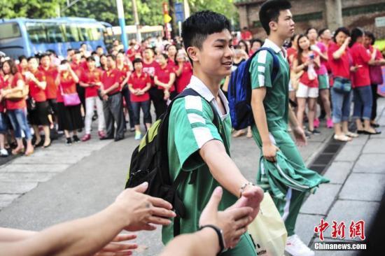 　资料图：一名考生身后站满了身穿红衣为考生助威的家长。中新社记者 陈骥旻 摄