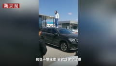 哈尔滨女车主站车顶维权:我没学历 就