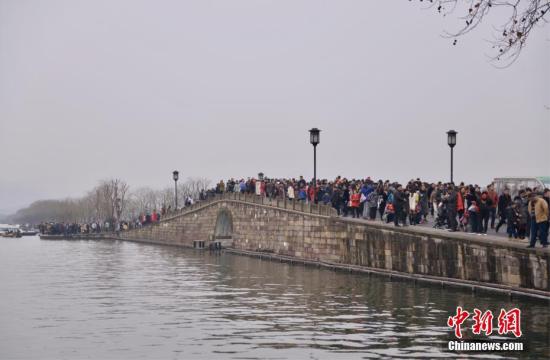 资料图：杭州西湖景区内的断桥上游人如织。
中新社记者 李晨韵 摄