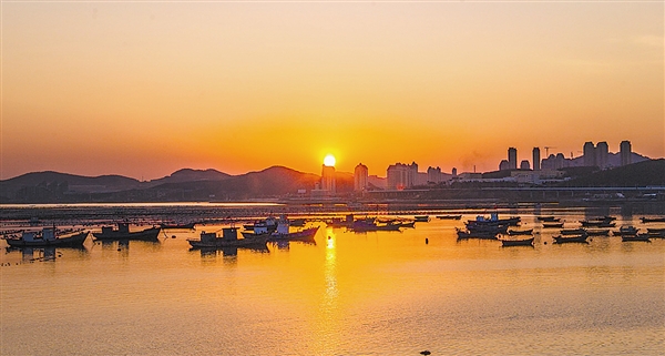 工人们每天要在海上往返四趟，进行海带收割。海面在夕阳的照耀下显得绚丽多彩；经过一天的劳作，满载而归的工人已回家休息，船静静地停在海湾修身养性，等待第二天的曙光！