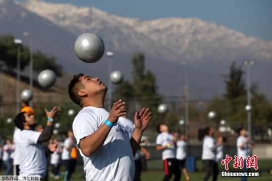 资料图：智利圣地亚哥，数百人同时顶球5秒，试图创造一项新的吉尼斯世界纪录。