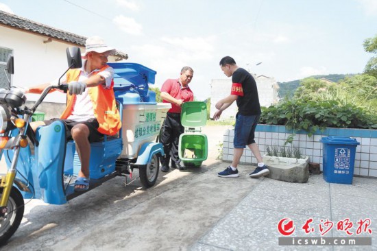 　　在澄潭村，參加主題黨日活動的“黨員督導員”幫助保潔員把可回收垃圾放上車。
顏開雲 攝