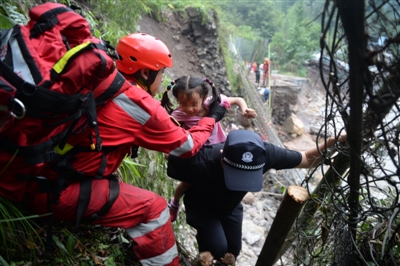 救援队沿着陡峭山路转移滞留人员