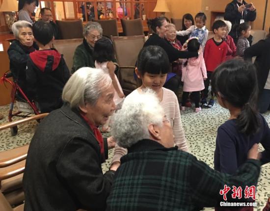 资料图：敬老院老人们与幼儿园小朋友一起做游戏。中新社记者 杜燕 摄
