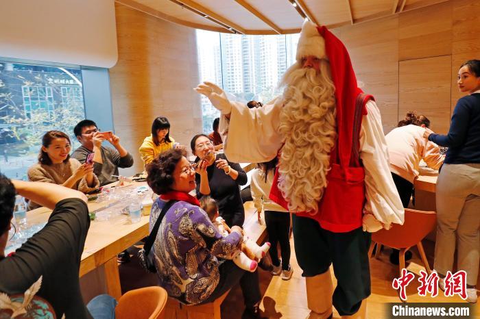 来自芬兰罗瓦涅米圣诞老人村的圣诞老人与上海市民亲密接触。　殷立勤 摄