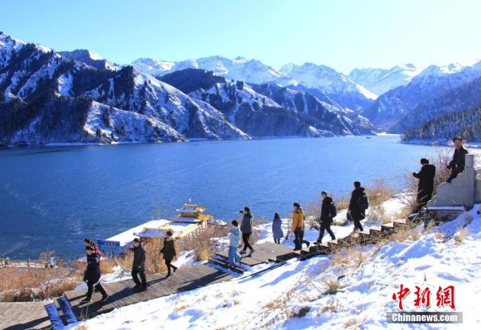 资料图：新疆天山天池景区内，来自国内外的游人徜徉在初冬的雪景里，如痴如醉。甄梅 摄