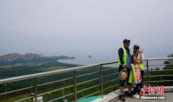 资料图：韩国民众在金刚山展望台合影，身后为朝鲜境内的金刚山。中新社记者 曾鼐 摄