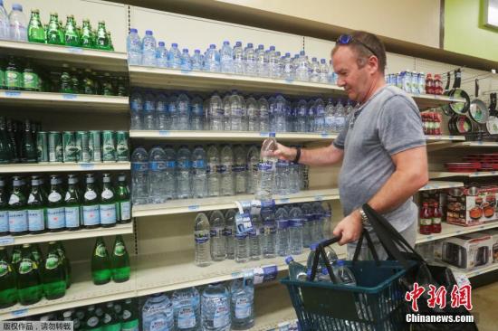 资料图：人们在超市采购生活用品和淡水。