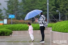 雨中漫步:市南海边游客游览美景