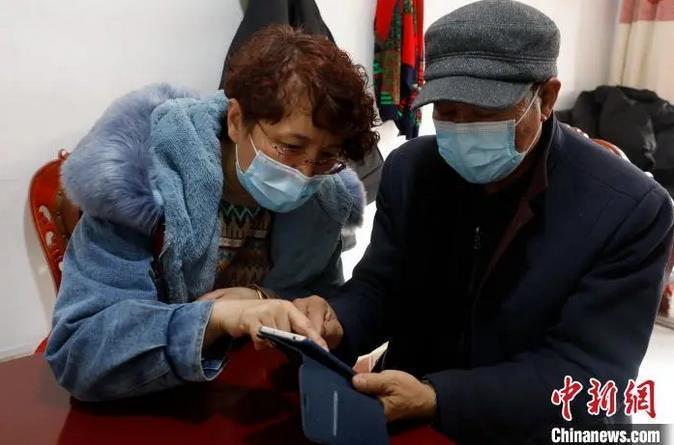 资料图：一社区工作者正在教老年人使用智能手机。杨迪 摄